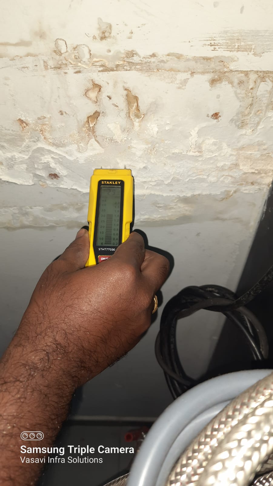 Moisture meter on damaged ceiling